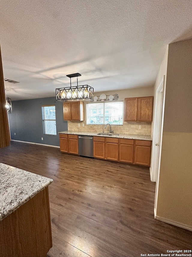 kitchen featuring decorative light fixtures, tasteful backsplash, sink, dark hardwood / wood-style flooring, and stainless steel dishwasher