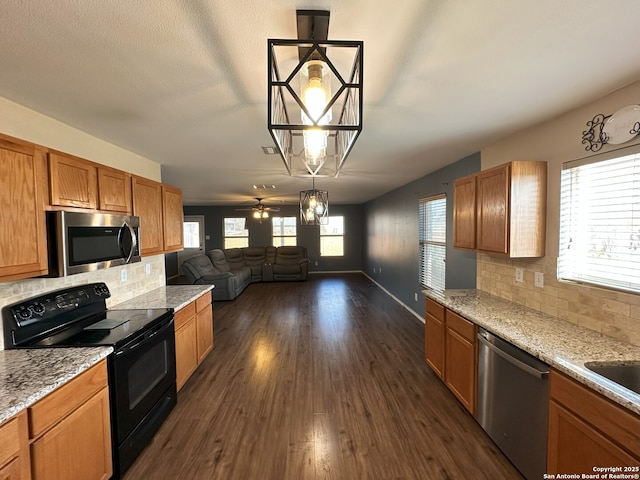 kitchen with decorative light fixtures, appliances with stainless steel finishes, dark hardwood / wood-style flooring, ceiling fan, and decorative backsplash