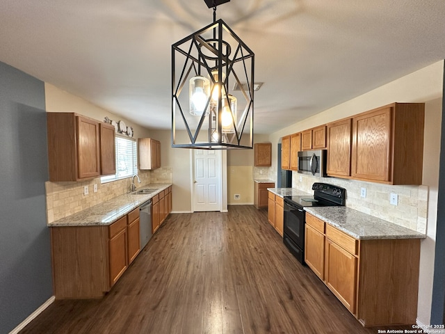 kitchen featuring dark hardwood / wood-style flooring, sink, decorative light fixtures, and stainless steel appliances