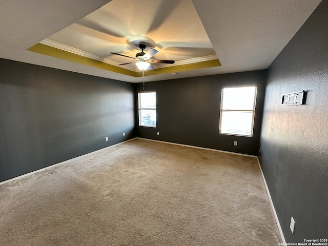 unfurnished room featuring crown molding, ceiling fan, carpet flooring, and a raised ceiling