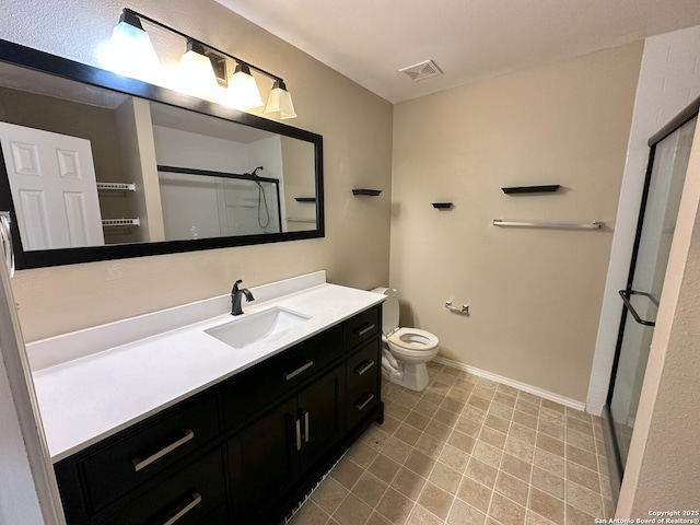 bathroom with vanity, toilet, and a shower with door