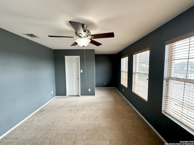 spare room with light colored carpet and ceiling fan