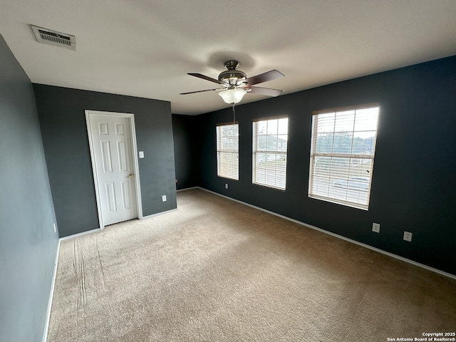 carpeted spare room with ceiling fan