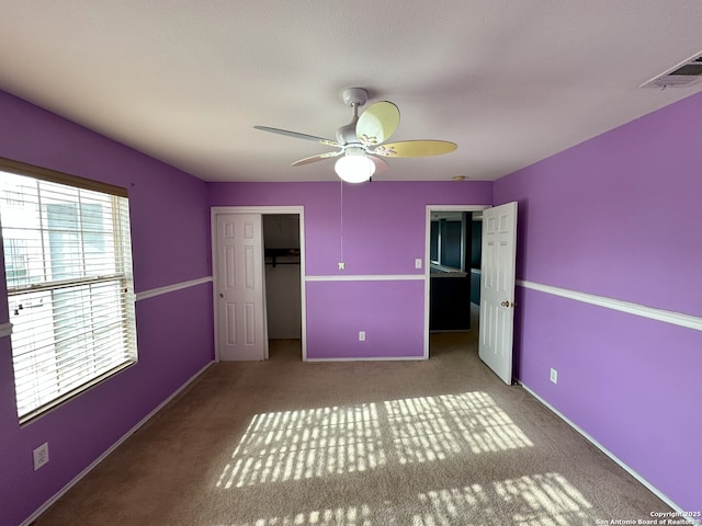 unfurnished bedroom with ceiling fan, carpet floors, and a closet