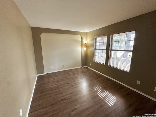 empty room with dark hardwood / wood-style flooring