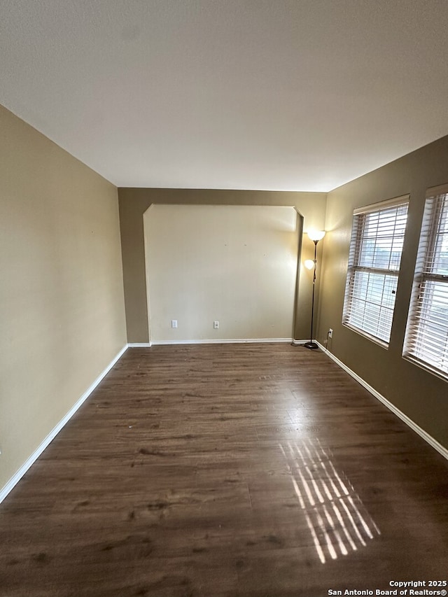 empty room with dark hardwood / wood-style flooring