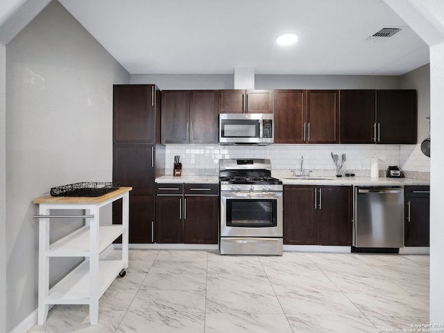 kitchen with marble finish floor, appliances with stainless steel finishes, dark brown cabinets, and a sink