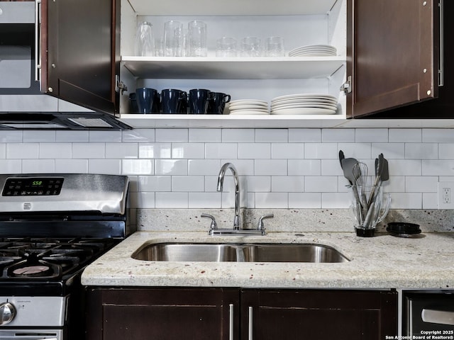 kitchen with dark brown cabinets, stainless steel gas range oven, and decorative backsplash