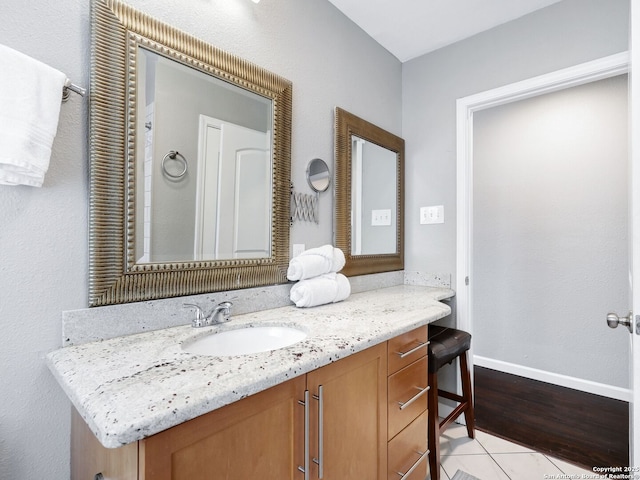 bathroom with tile patterned floors, baseboards, and vanity