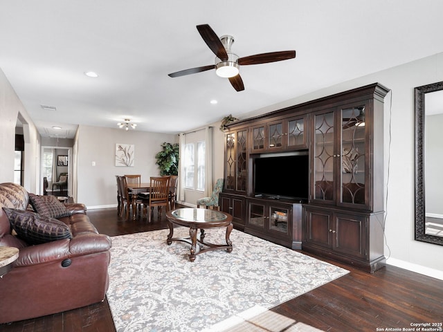 living room with baseboards, visible vents, and dark wood-style flooring