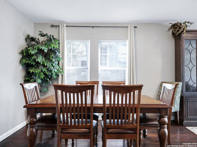 dining area featuring dark wood-style flooring and baseboards