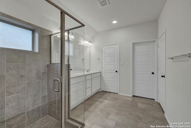 bathroom featuring vanity and a shower with door