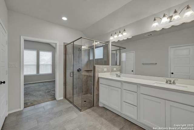 bathroom with a shower with door and vanity