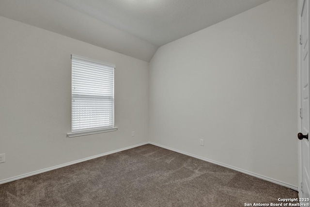 empty room with carpet flooring and vaulted ceiling