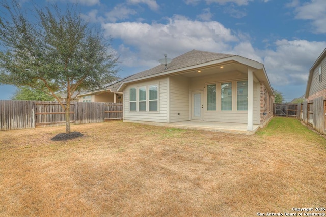 rear view of house with a yard and a patio area