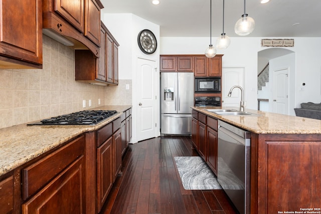 kitchen with sink, light stone counters, dark hardwood / wood-style flooring, an island with sink, and black appliances