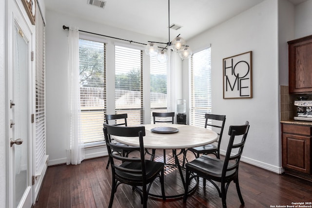 dining area featuring dark hardwood / wood-style floors and an inviting chandelier