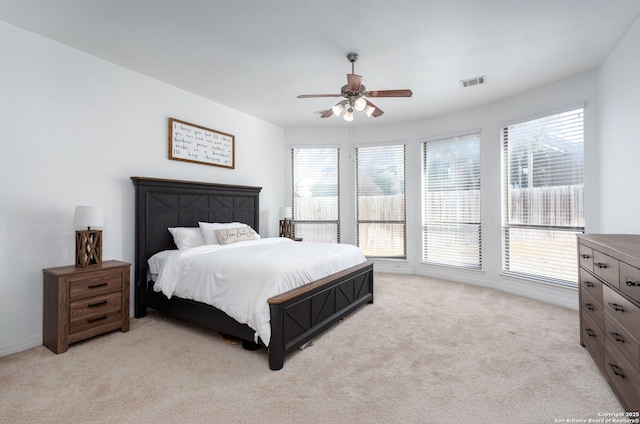 bedroom featuring light carpet, multiple windows, and ceiling fan