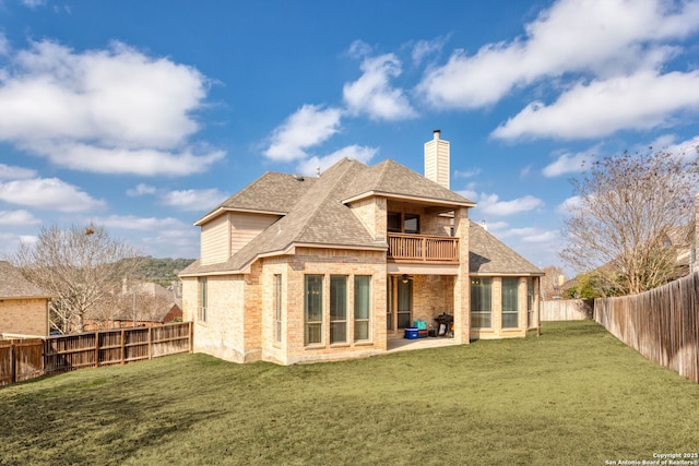 rear view of house with a patio, a balcony, and a lawn