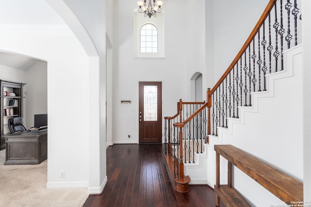 foyer featuring a notable chandelier, dark hardwood / wood-style floors, a high ceiling, and a wealth of natural light