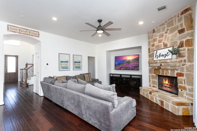 living room featuring ceiling fan, a fireplace, and dark hardwood / wood-style flooring