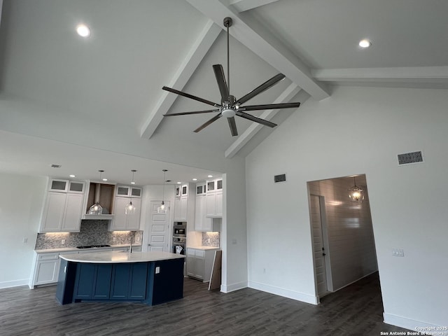 kitchen with tasteful backsplash, visible vents, light countertops, and beamed ceiling