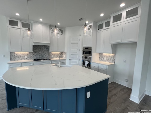 kitchen with gas stovetop, visible vents, double oven, white cabinetry, and a sink