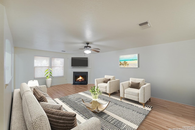 living room with light hardwood / wood-style flooring and ceiling fan