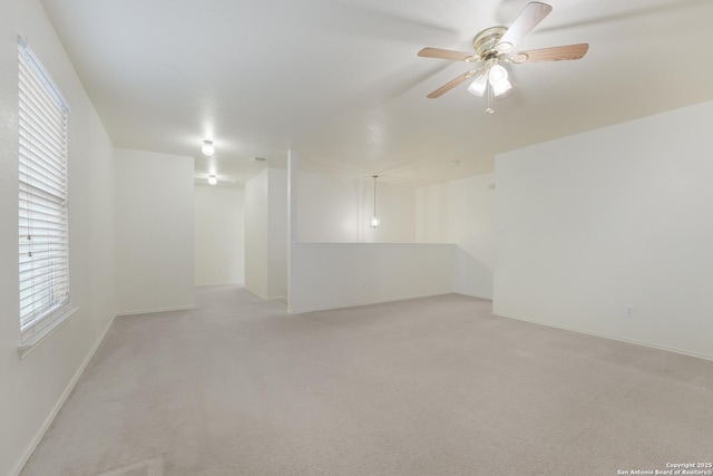 carpeted spare room featuring ceiling fan