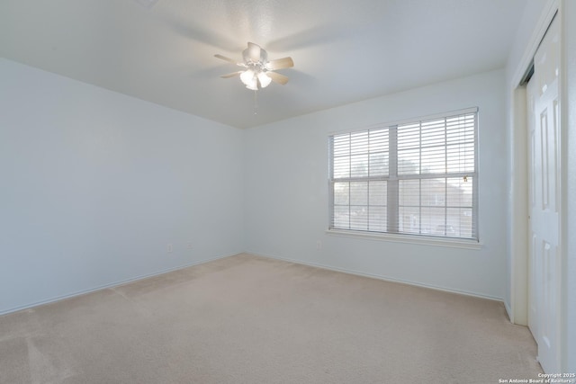 unfurnished room with light colored carpet and ceiling fan