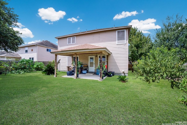 back of house with a patio and a lawn