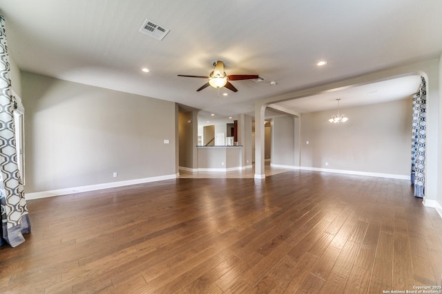 unfurnished living room featuring dark hardwood / wood-style flooring and ceiling fan with notable chandelier