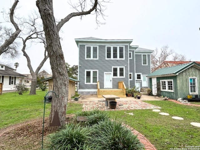 back of house with a yard, an outbuilding, and a patio