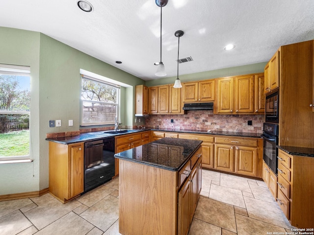 kitchen featuring a kitchen island, pendant lighting, tasteful backsplash, sink, and black appliances