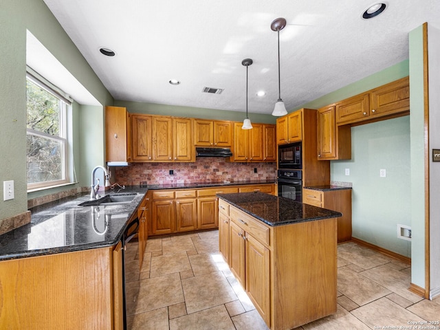 kitchen featuring sink, tasteful backsplash, hanging light fixtures, a kitchen island, and black appliances