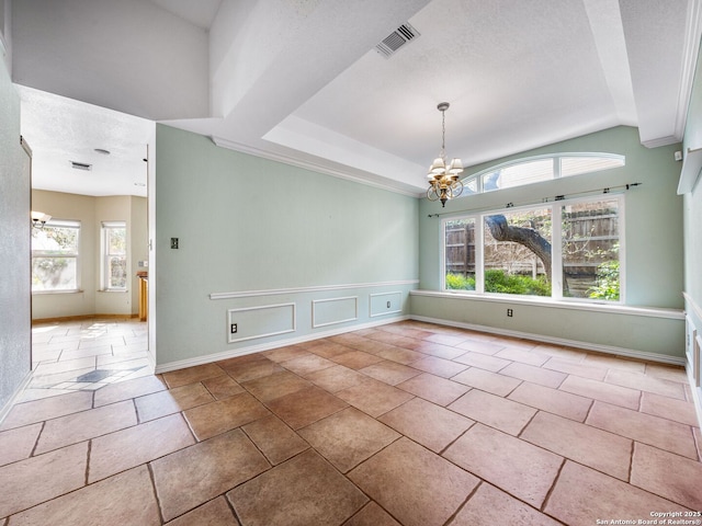 empty room featuring vaulted ceiling, a textured ceiling, and a chandelier