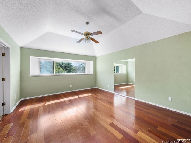 unfurnished room featuring vaulted ceiling, ceiling fan, hardwood / wood-style floors, and a textured ceiling