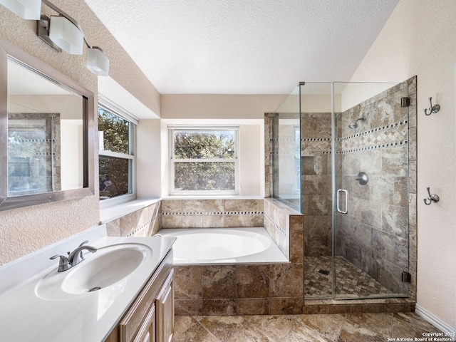 bathroom with vanity, a textured ceiling, and separate shower and tub