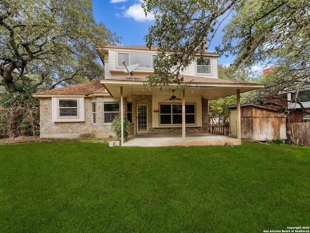 back of property with a yard, a patio, ceiling fan, and a storage unit