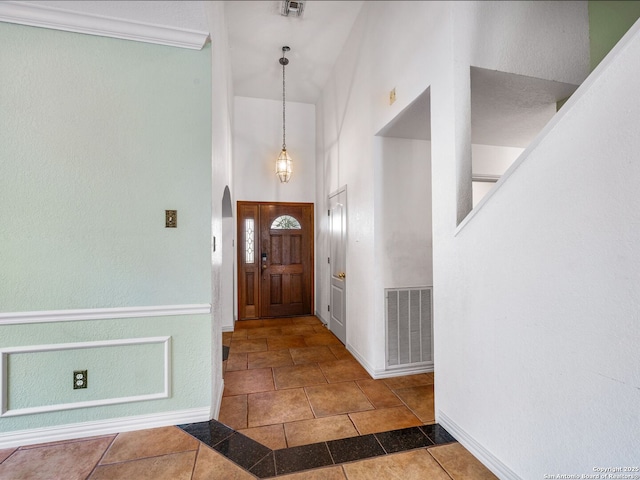 tiled entrance foyer with a high ceiling