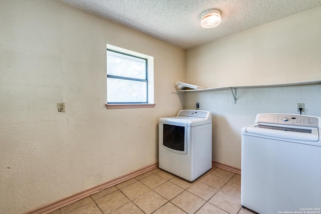 clothes washing area featuring independent washer and dryer, a textured ceiling, and light tile patterned floors