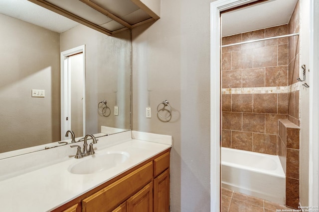 bathroom with tiled shower / bath, vanity, and tile patterned floors