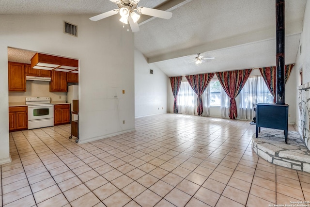 unfurnished living room featuring beam ceiling, light tile patterned flooring, a textured ceiling, and a wood stove