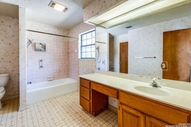 full bathroom featuring vanity, tiled shower / bath, a textured ceiling, and toilet