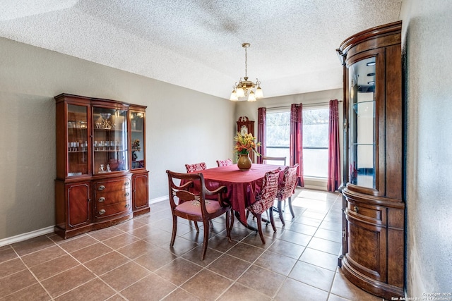 tiled dining space featuring a chandelier and a textured ceiling