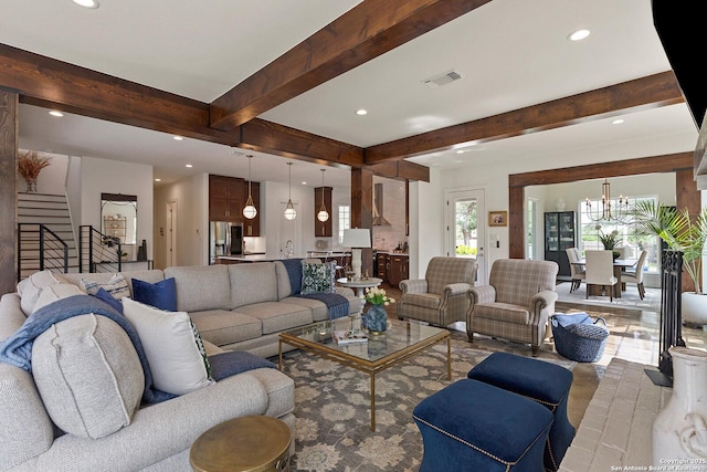 living area with beam ceiling, recessed lighting, stairs, and a chandelier