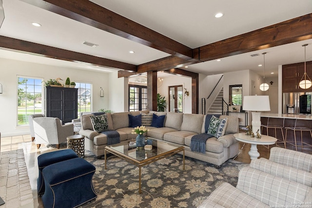 living area with beam ceiling, recessed lighting, and stairs