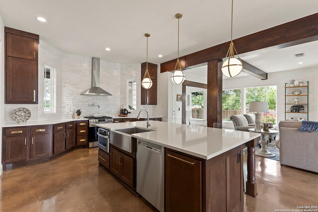 kitchen featuring wall chimney range hood, stainless steel appliances, a sink, finished concrete floors, and open floor plan