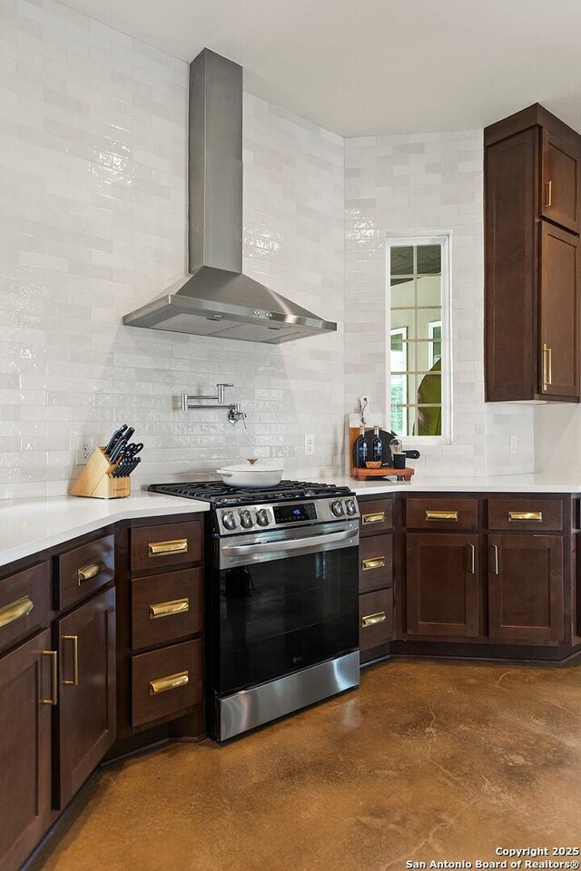 kitchen featuring stainless steel range with gas cooktop, wall chimney range hood, tasteful backsplash, and light countertops