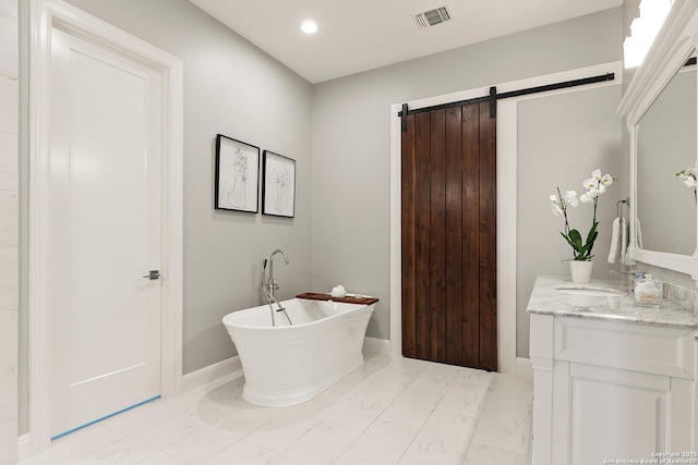 full bathroom with marble finish floors, a freestanding tub, vanity, baseboards, and recessed lighting